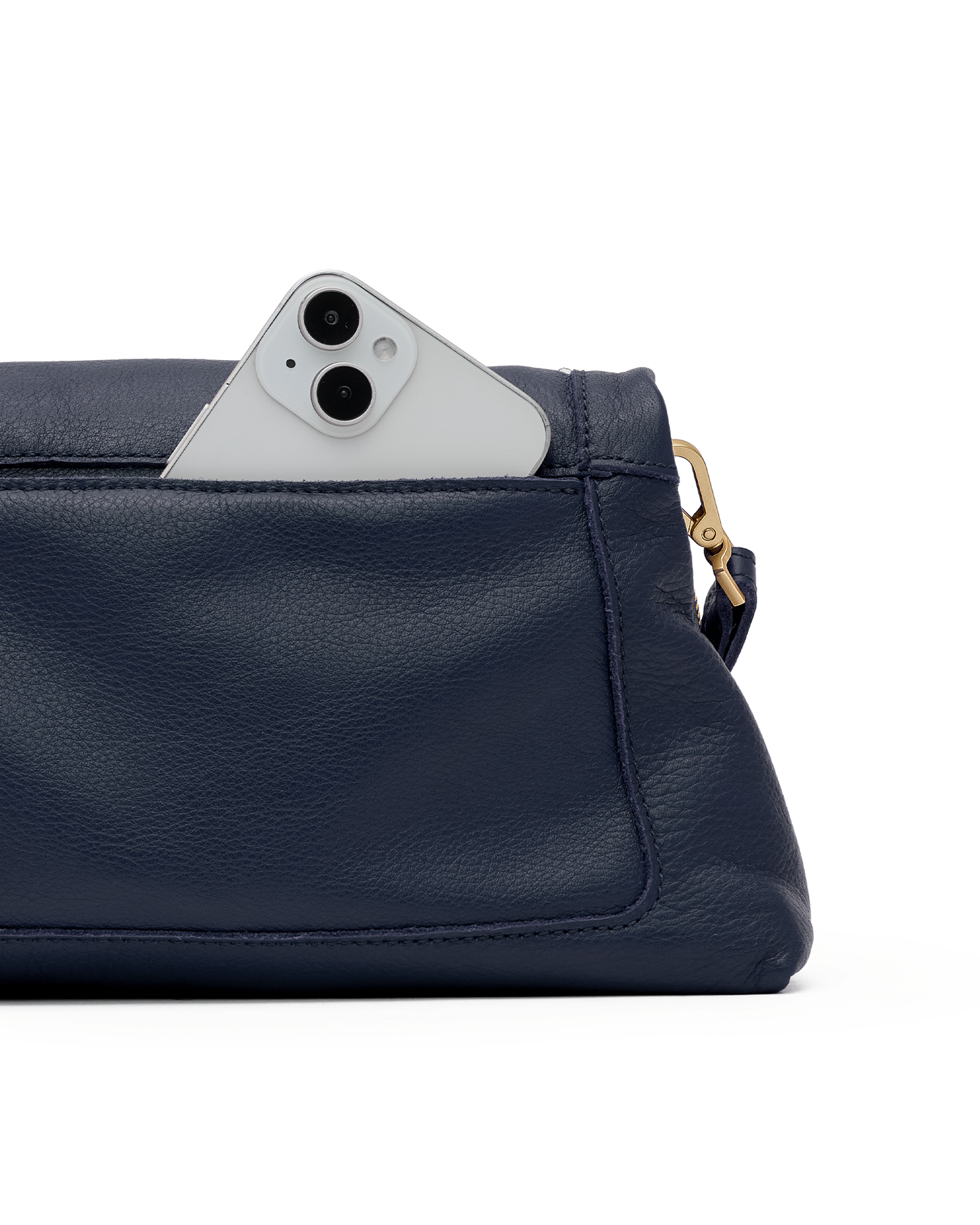 A close-up of a navy blue pebbled leather pouch or clutch with a white smartphone partially tucked into the top pocket, showing a gold-tone ring pull on a white background.