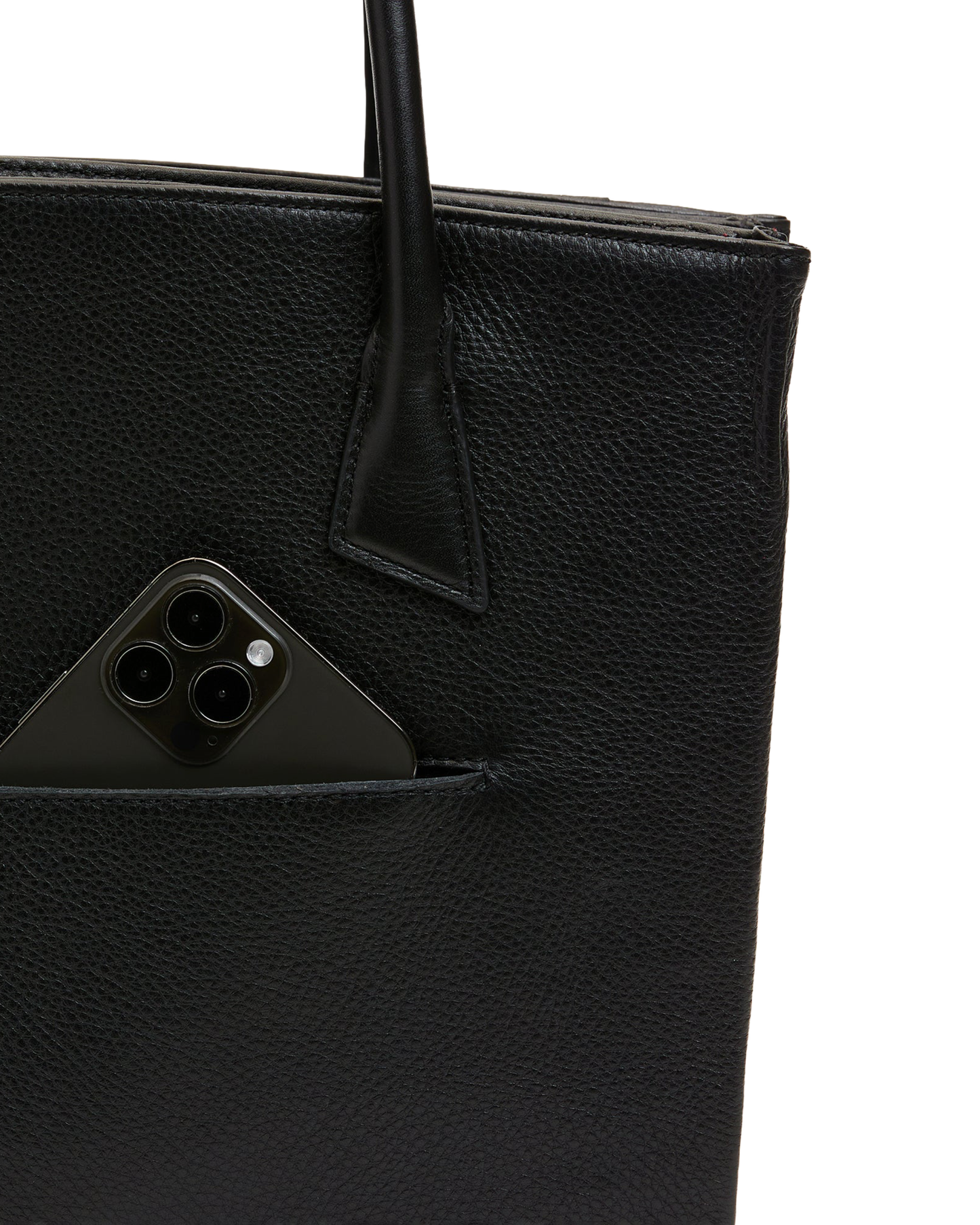 Close-up of a black pebbled leather tote bag with a side pocket holding a black smartphone, on a white background.