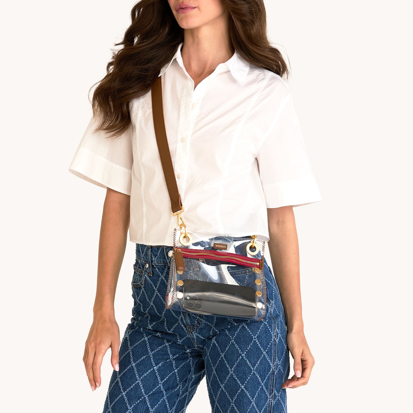 Woman wearing a transparent waist bag with a brown strap on a white background