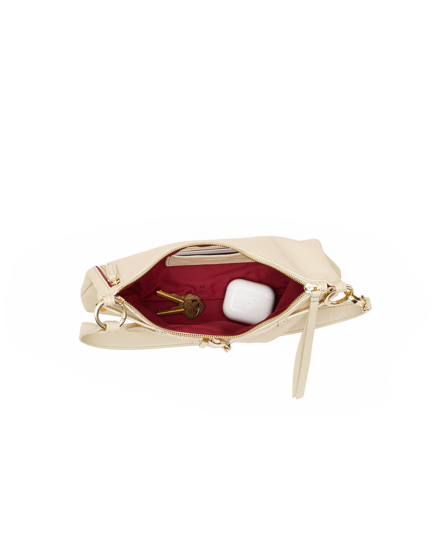 A cream-colored leather clutch bag shown open, revealing a deep burgundy red interior lining with gold-tone hardware, including a zipper pull and a ring clasp. The bag is photographed on a seamless white background.