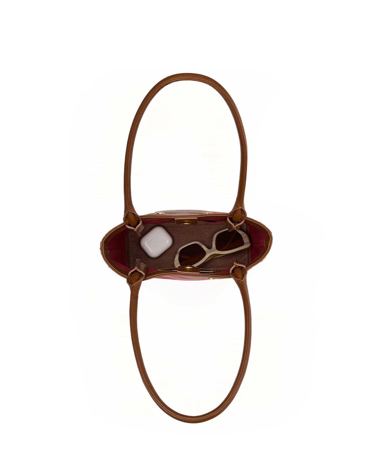 A brown leather handbag shown from a top-down view, containing sunglasses and a small white accessory, set against a plain white background.
