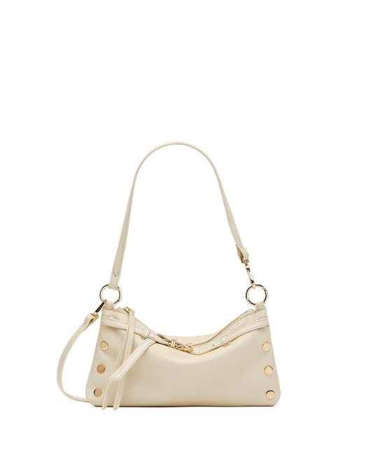 A cream-colored faux leather shoulder bag with gold-tone hardware, featuring a crescent-shaped body, decorative rivets, and a matching shoulder strap, shown against a plain white background.