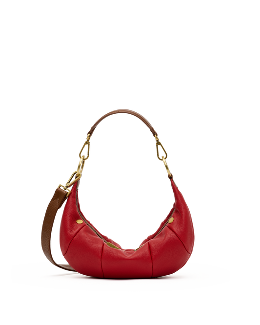 A red leather crescent-shaped shoulder bag with gold-tone hardware and a brown shoulder strap, shown on a plain white background.