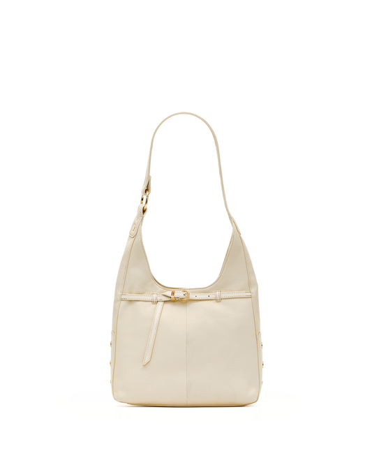 A light beige leather shoulder bag with a single strap and a decorative front strap detail, shown against a plain white background.