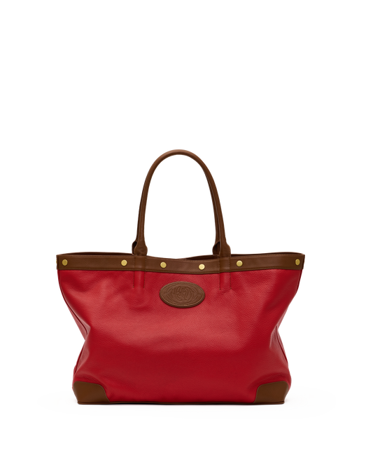 A red leather tote bag with brown leather trim, double top handles, gold-tone hardware, and a circular embossed logo patch on the front, shown against a plain white background.