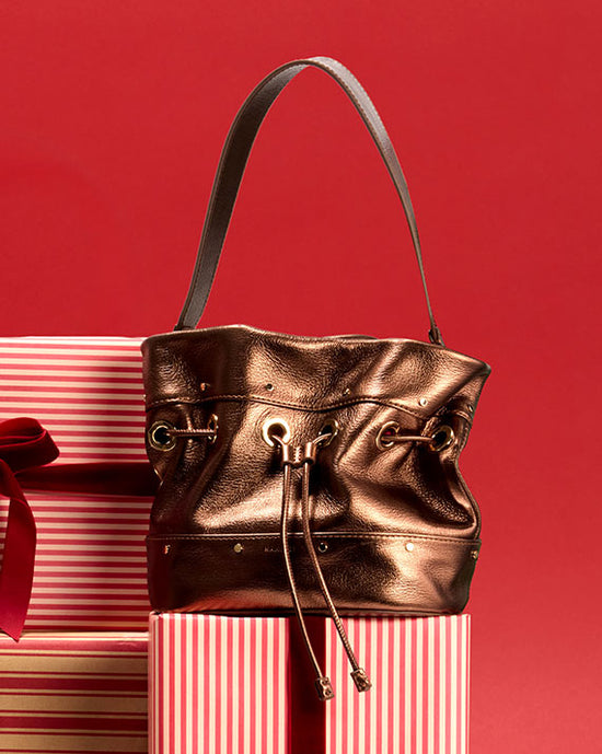 Gianna Sml Bronze on top of gift boxes