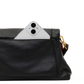 Close-up of a black pebbled leather clutch or crossbody bag with a white smartphone partially tucked into the top pocket, showing a gold-tone hardware detail and a hint of red lining on a white background.