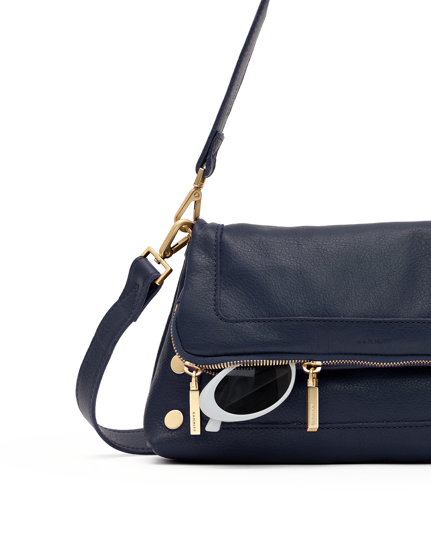 A navy blue leather shoulder bag with gold-tone hardware and a visible silver-tone Q logo charm, shown against a plain white background.