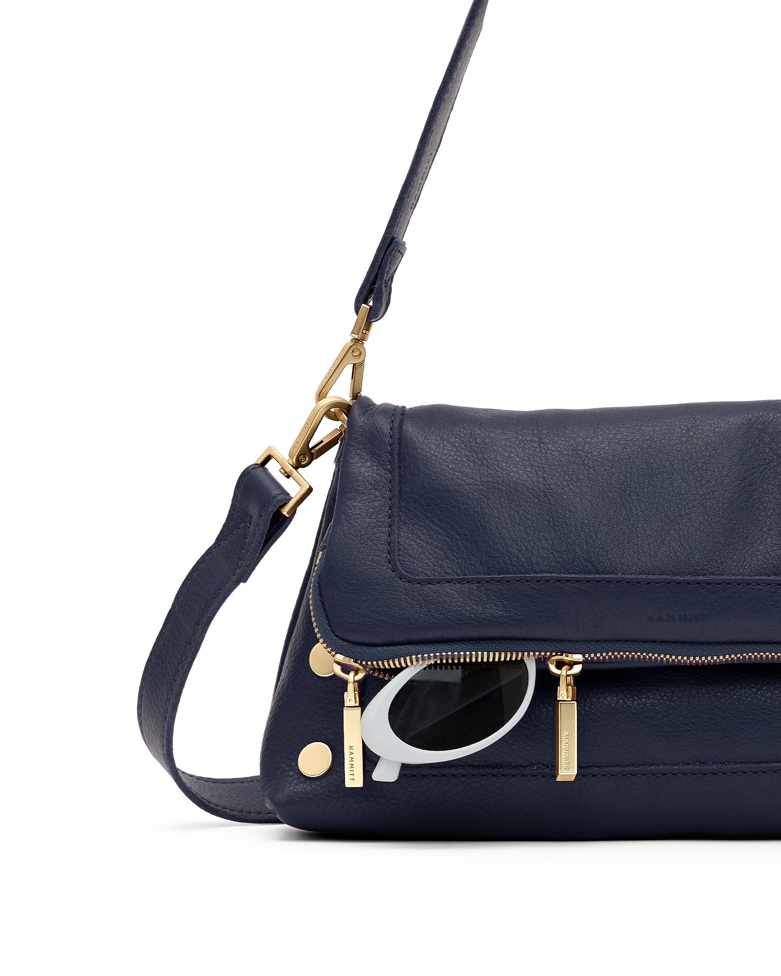 A navy blue leather shoulder bag with gold-tone hardware and a visible silver-tone Q logo charm, shown against a plain white background.