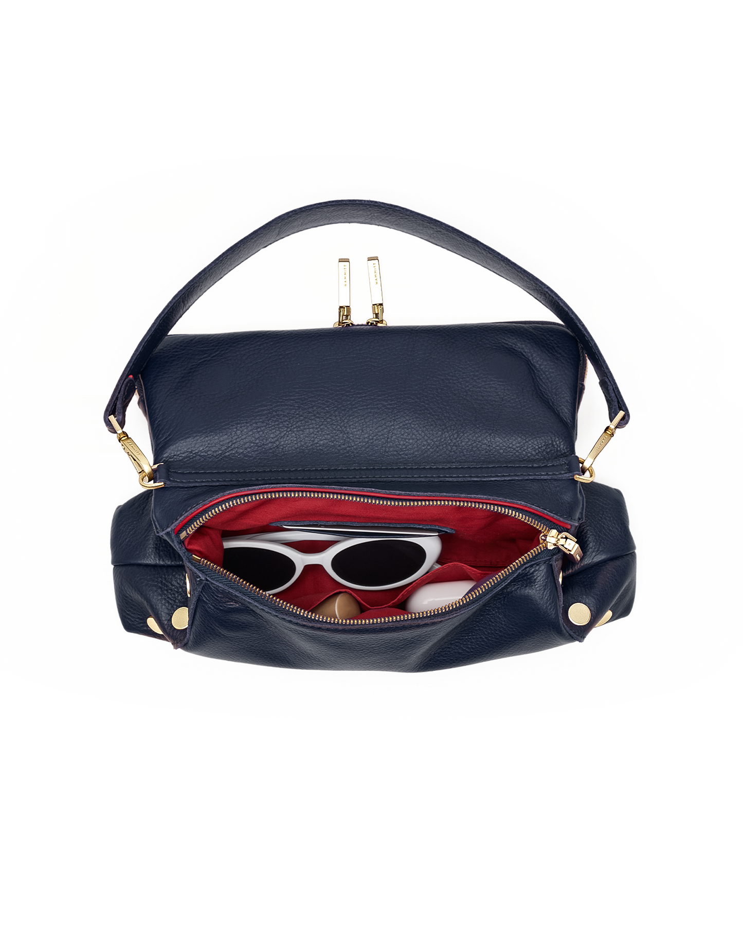 A navy blue leather shoulder bag with gold-tone hardware, shown open to reveal a red interior lining and sunglasses inside, set against a plain white background.