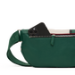 A green pebbled leather crossbody bag with a matching adjustable strap, shown in profile with a black smartphone partially tucked into the zippered pocket. The background is a clean white studio backdrop.