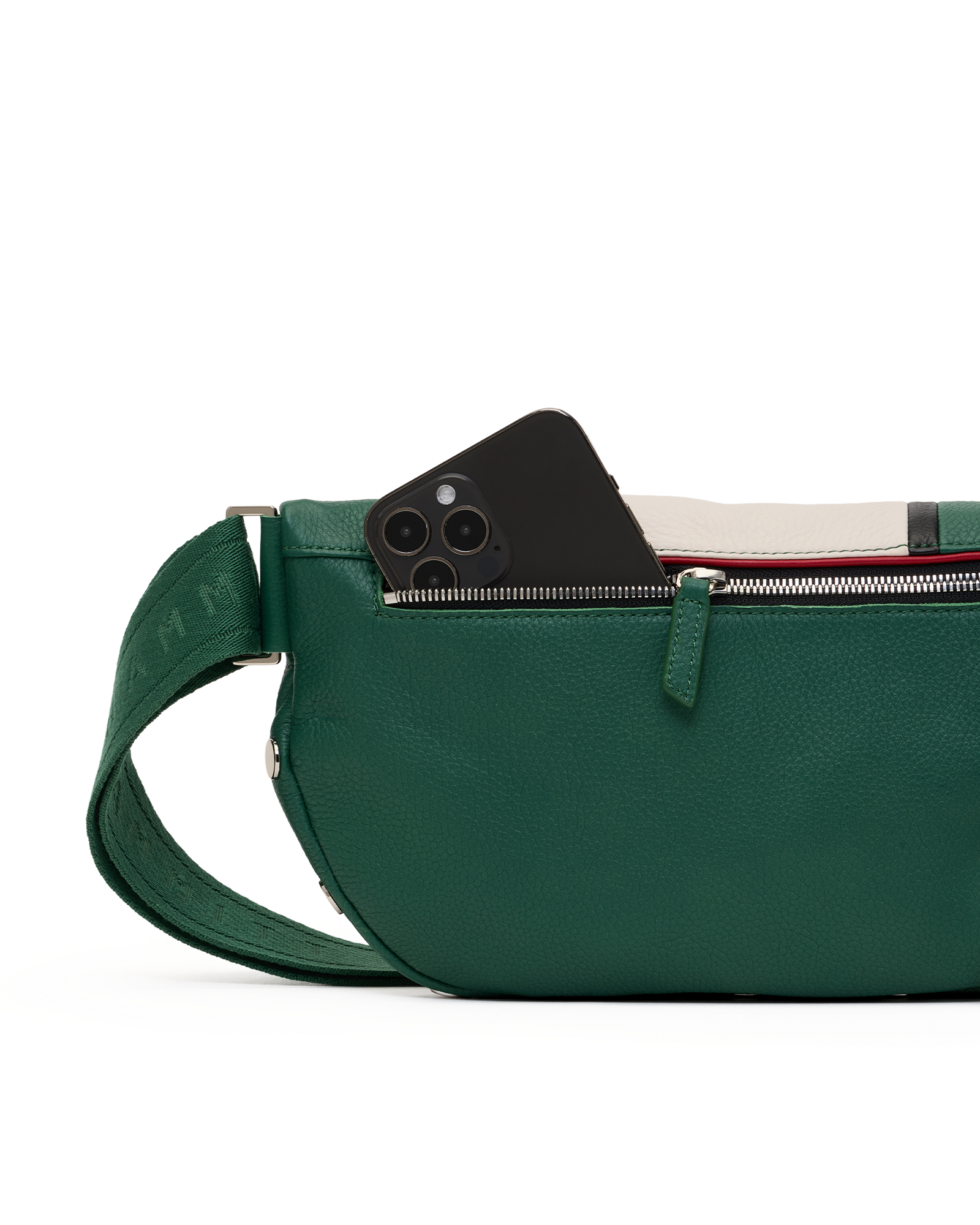 A green pebbled leather crossbody bag with a matching adjustable strap, shown in profile with a black smartphone partially tucked into the zippered pocket. The background is a clean white studio backdrop.