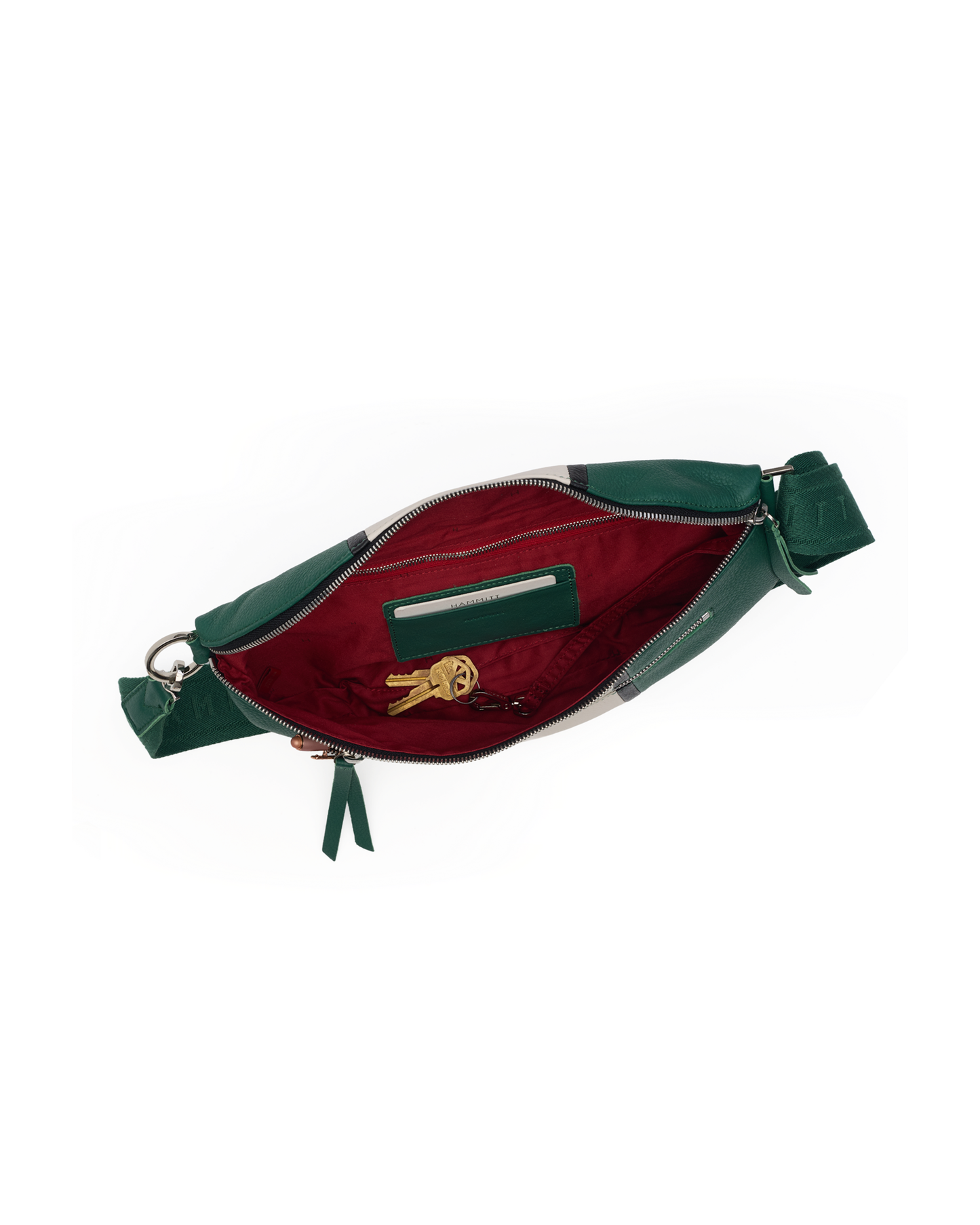 A green leather waist bag shown open, revealing a deep burgundy red interior lining with a zippered pocket and a small gold keychain inside.
