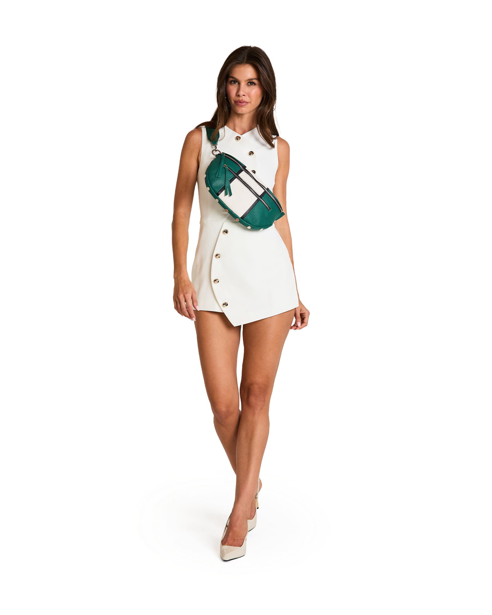 A woman modeling a white sleeveless double-breasted mini dress with gold buttons, accessorized with a green and white striped crossbody bag, on a solid white background.