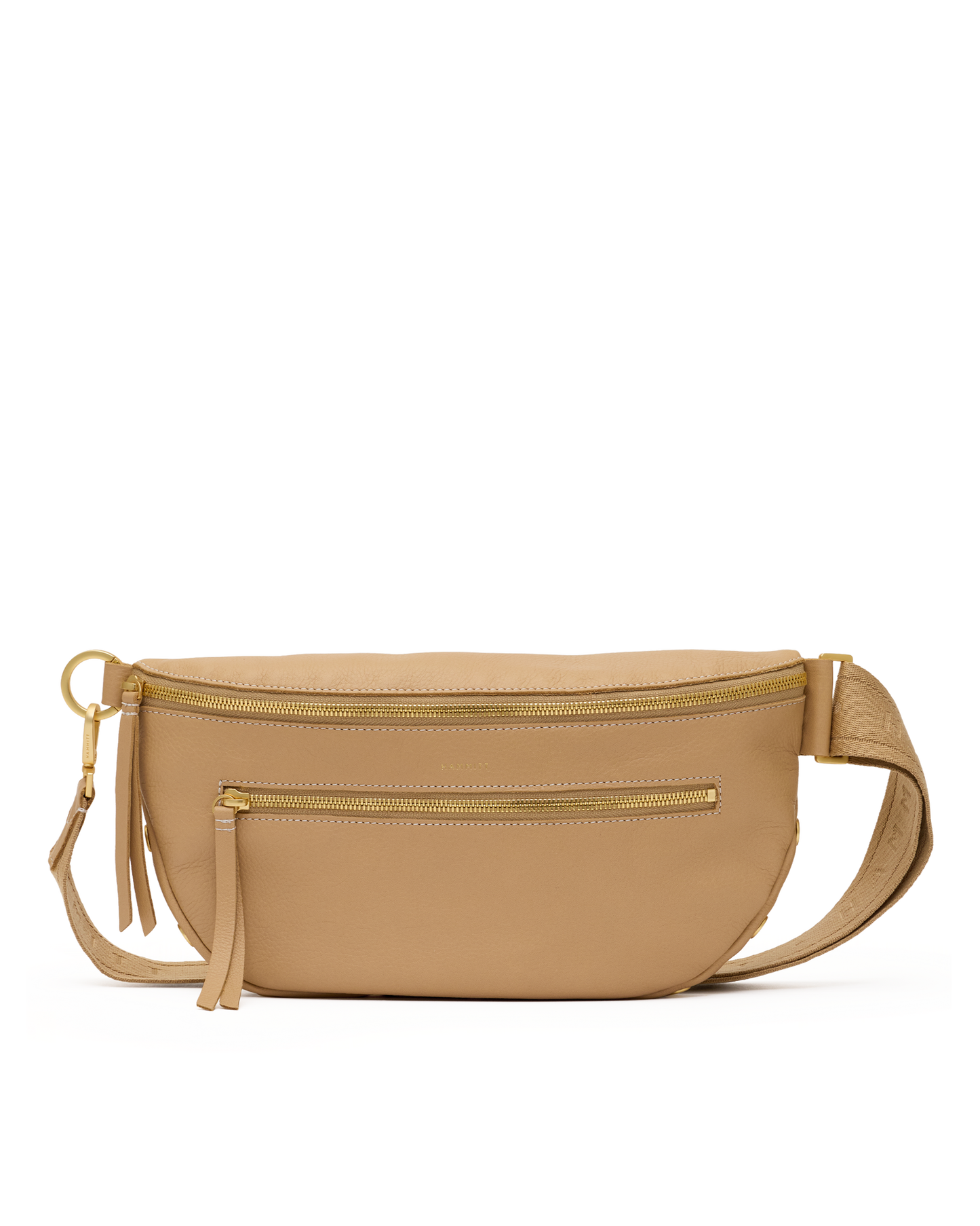 A tan leather waist bag with gold-tone hardware, featuring a top zipper, a front zip pocket, a tassel charm, and an adjustable shoulder strap, shown against a plain white background.