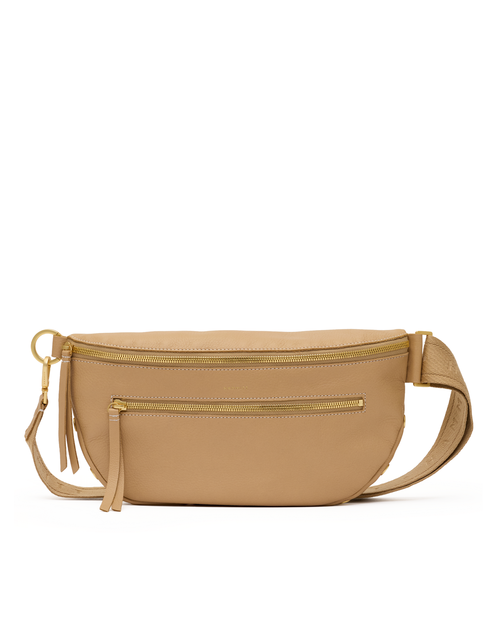 A tan leather waist bag with gold-tone hardware, featuring a top zipper, a front zip pocket, a tassel charm, and an adjustable shoulder strap, shown against a plain white background.