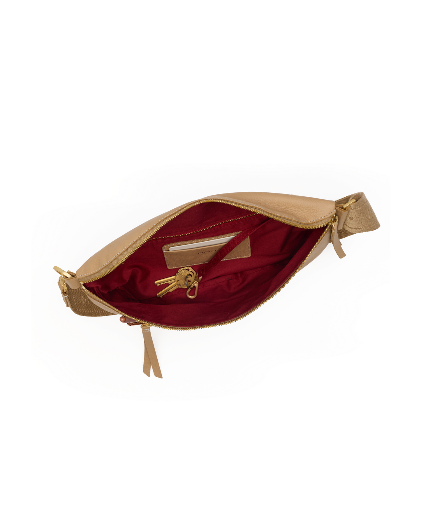 A tan leather waist bag shown open, revealing a deep burgundy red satin lining with a gold-tone zipper and interior card slots.