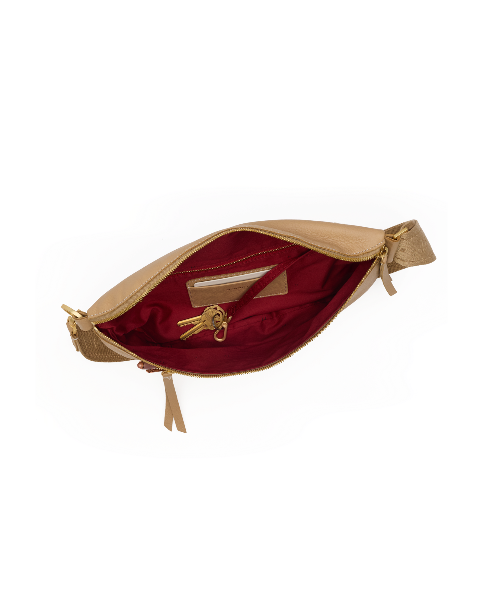 A tan leather waist bag shown open, revealing a deep burgundy red satin lining with a gold-tone zipper and interior card slots.