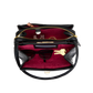 Black handbag with red interior containing sunglasses and a key on a white background