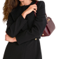 A woman wearing a black long-sleeve coat or dress, carrying a burgundy leather shoulder bag with gold hardware against a plain white background.