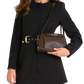 A woman wearing a black coat with a gold-tone belt buckle and carrying a dark brown leather shoulder bag.