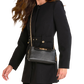 A woman wearing a black tailored coat and black tights carries a black leather crossbody bag with gold-tone chain straps and hardware.