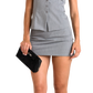 A woman wearing a light gray two-piece set consisting of a sleeveless button-front top and a matching mini skirt, holding a black quilted clutch with a silver clasp against a plain white background.