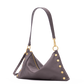 A dark gray pebbled leather shoulder bag with gold-tone hardware, featuring a slouchy triangular silhouette, gold rivet details along the edges, and a zippered top closure, shown against a plain white background.