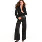 A woman modeling a black satin-like blazer and matching wide-leg trousers, holding a black leather handbag.