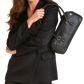 A woman in a black blazer and trousers carries a structured black leather shoulder bag with a top handle.