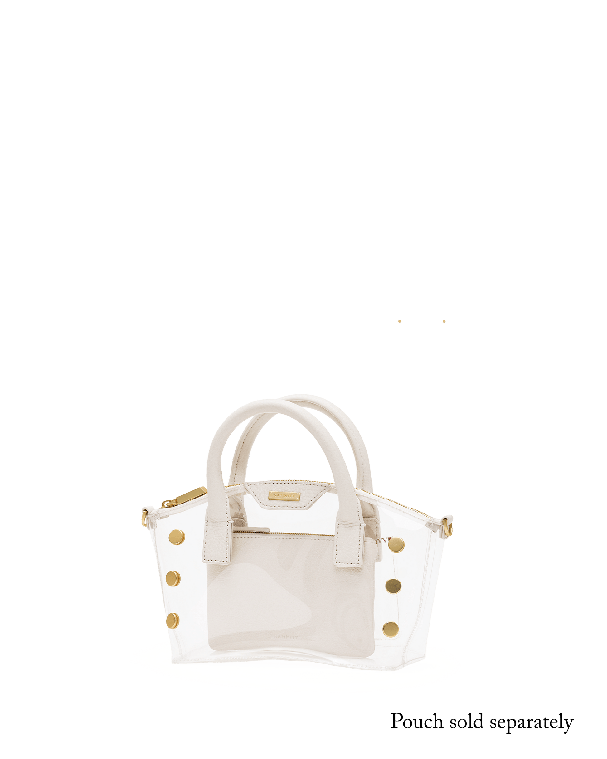 A structured handbag with a transparent clear front panel and cream-colored faux leather trim, handles, and side panels, accented with gold-tone studs and hardware.