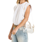 A woman wearing a white sleeveless top, light blue jeans, and a gold belt, carrying a clear structured handbag with gold hardware and a white top handle.