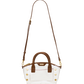 A clear acrylic handbag with brown leather handles, trim, and a shoulder strap, accented by gold-tone studs and hardware.