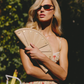 Woman holding a beige handbag.