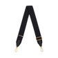 A black fabric camera strap with gold-tone hardware, featuring a repeating monogram pattern and adjustable buckle.