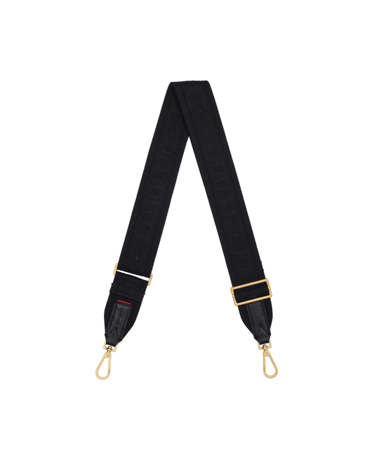 A black fabric camera strap with gold-tone hardware, featuring a repeating monogram pattern and adjustable buckle.