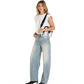 A woman modeling light-wash wide-leg denim jeans with a white sleeveless top, black pointed shoes, and a black-and-white shoulder bag.
