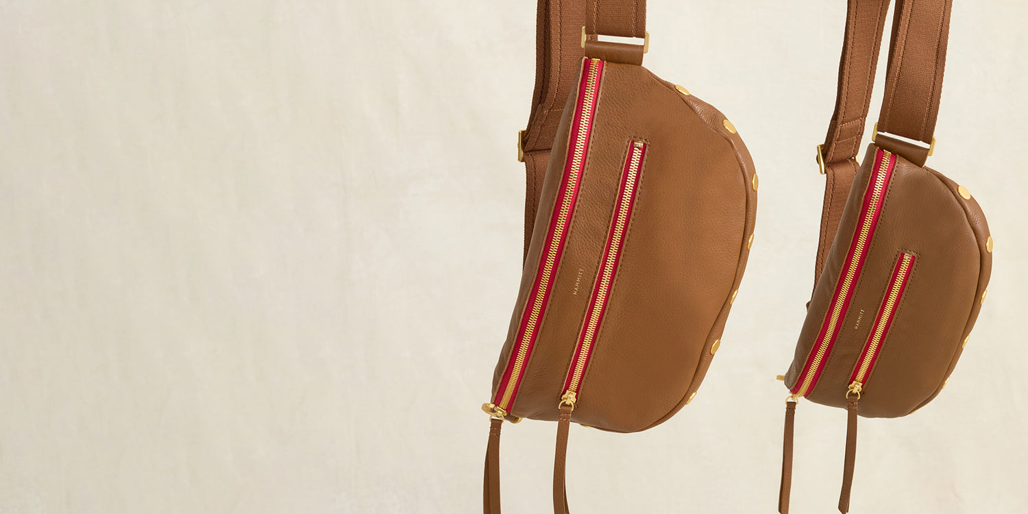 Two charles in mahogany pebble brushed gold red zip hanging side by side. sizes shown are med and lrg.