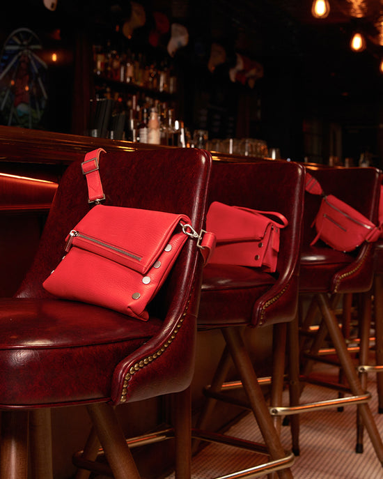 Image of Lighthouse Red Collection on bar stools at Lighthouse Cafe. Bags shown from collection are VIP med, Curtis, and Charles