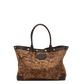 A structured tote bag with a brown and gold glittery woven body, dark brown leather trim, double top handles, and gold-tone hardware, shown against a plain white background.