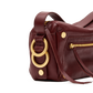 A close-up of a dark burgundy leather handbag featuring large gold-tone double rings and gold hardware on a white background.