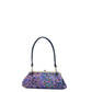 A small handbag with a multicolor floral pattern in purple, blue, and orange, featuring a dark navy blue shoulder strap and a silver-tone metal frame closure, shown against a plain white background.
