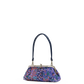 A small handbag with a dark navy blue handle and a colorful abstract patterned body in shades of purple, blue, and orange, featuring a silver-tone metal frame closure.