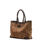A brown textured tote bag with dark brown leather handles, trim, and base, accented with gold-tone rivets and hardware, shown against a plain white background.