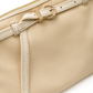 Close-up of a cream-colored leather pouch featuring a matching leather strap with a gold-tone buckle and zipper pull.