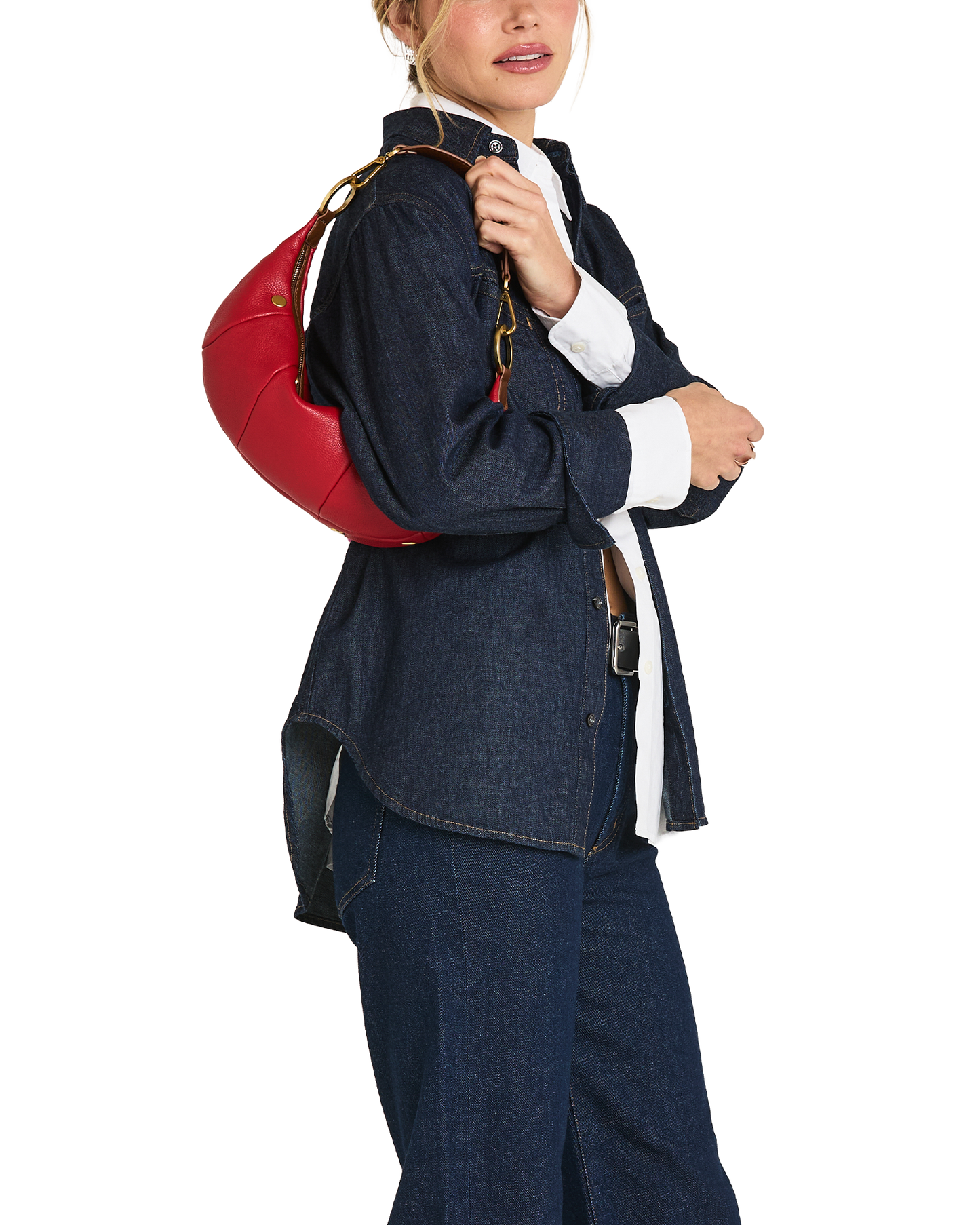 A model wearing a dark blue denim jacket and matching wide-leg jeans, carrying a bright red round shoulder bag with a gold chain strap over her shoulder, against a plain white background.