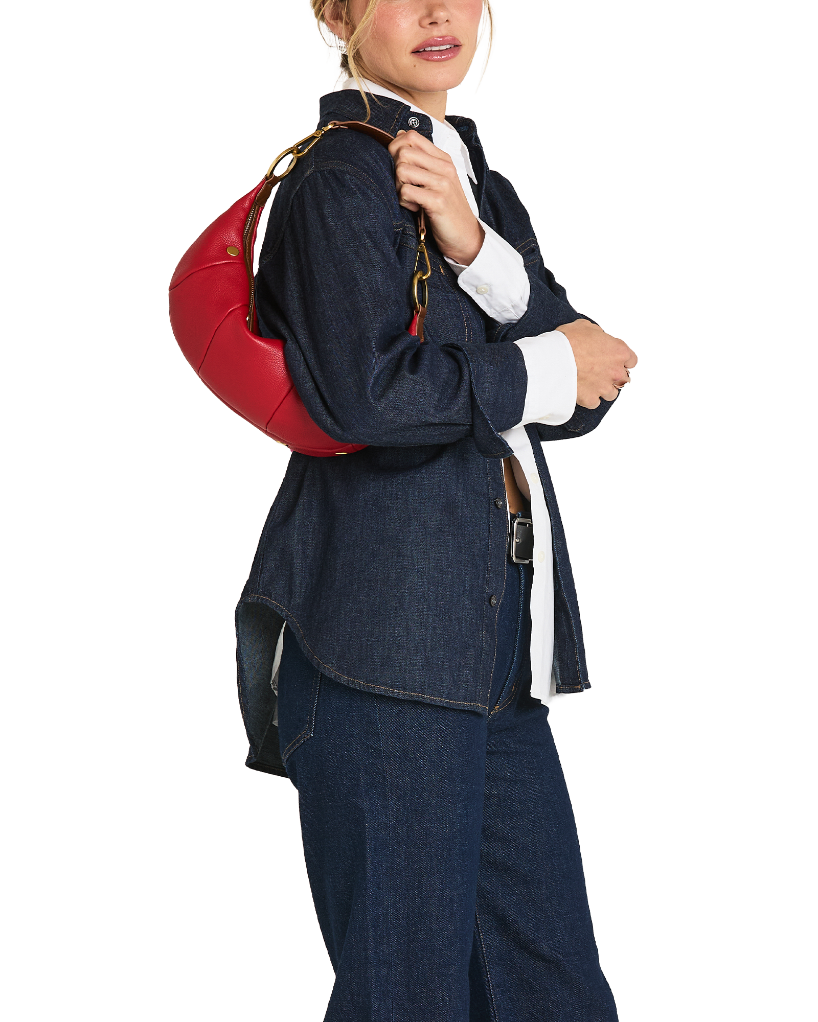 A model wearing a dark blue denim jacket and matching wide-leg jeans, carrying a bright red round shoulder bag with a gold chain strap over her shoulder, against a plain white background.