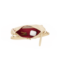 A cream-colored leather clutch bag shown open, revealing a deep burgundy red interior lining with gold-tone hardware, including a zipper pull and a ring clasp. The bag is photographed on a seamless white background.