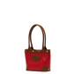 A red leather tote bag with brown leather handles, trim, and corner panels, accented with gold-tone hardware and a circular brown logo patch on the front.