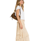 A woman in a white t-shirt and a beige ruffled tiered maxi skirt is shown from the side, carrying a brown leather shoulder bag against a solid white background.